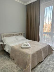 ein Schlafzimmer mit einem Bett mit zwei Handtüchern darauf in der Unterkunft 4YOU апартаменты in Almaty