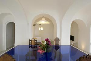 a hallway with a blue table with flowers on it at Eremo di Montevergine Ischia Apartments in Forio d'Ischia