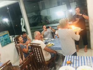 um grupo de pessoas sentadas à mesa a comer em Sunflower Inn em Dambulla