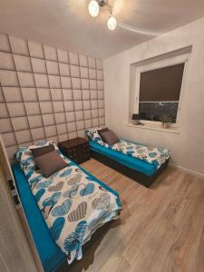 1 dormitorio con 2 camas y ventana en Apartament Panorama Miasta en Gdynia