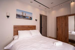 a bedroom with a white bed with a wooden headboard at Sun and Sand Guest House in Cairo