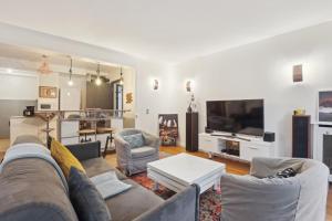 a living room with a couch and a tv at Chic and spacious apartement with piano and terrace in Le Chesnay