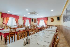 a dining room with tables and chairs and red curtains at Hotel Restaurante Cazador in Pereiro +7 photos