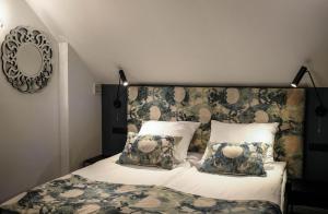 um quarto com uma cama com uma cabeceira e almofadas florais em Apartamenty Willa na Wzgórzu em Tarnów
