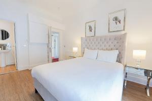 a bedroom with a large white bed and a bathroom at Edinburgh Castle Apartments in Edinburgh