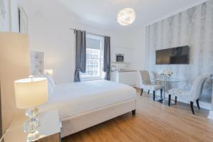 a white bedroom with a bed and a table and chairs at Edinburgh Castle Apartments in Edinburgh