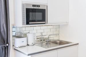 a kitchen counter with a sink and a microwave at Edinburgh Castle Apartments in Edinburgh