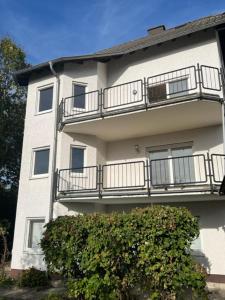 un edificio con balcones y un arbusto delante de él en Gartenparadies Apartment in Urbar, en Urbar