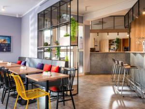 a restaurant with wooden tables and yellow chairs at ibis Kassel Melsungen in Melsungen