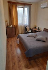 um quarto com uma cama, uma cadeira e uma janela em Guest House LEADER em Ijevan