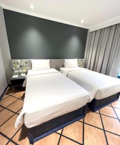 a hotel room with two beds and a wall at Phuket Island View Resort - SHA Extra Plus in Karon Beach