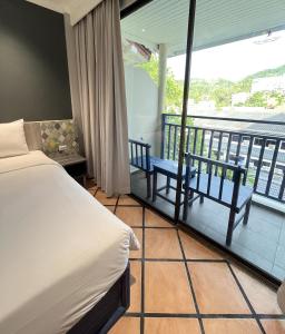 a hotel room with a bed and a balcony at Phuket Island View Resort - SHA Extra Plus in Karon Beach