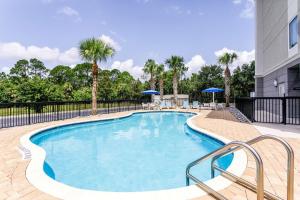 a large swimming pool with chairs and umbrellas at Hampton Inn Titusville/I-95 Kennedy Space Center in Titusville