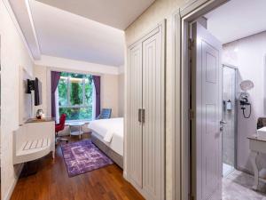 a bedroom with a bed and a walk in shower at Mercure Tbilisi Old Town in Tbilisi City