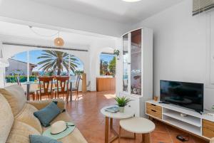 ein Wohnzimmer mit einem Sofa und einem TV in der Unterkunft Villa Salada - PlusHolidays in Calpe