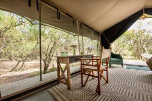 a room with a table and a chair in a tent at Olkinyei Mara Tented Camp in Talek