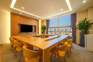 Ramada by Wyndham Incheon في انشيون: قاعة اجتماعات مع طاولة وكراسي خشبية كبيرة