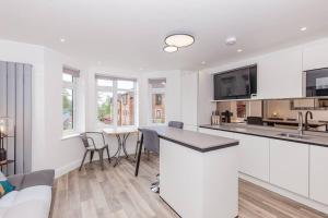 a white kitchen with a bar and a couch at Fantastic 2 Bedroom, 2 Bathroom Apartment Oxford in Oxford