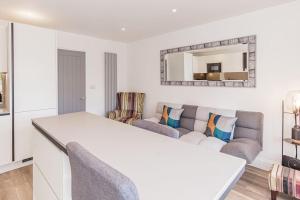 a white living room with a couch and a mirror at Fantastic 2 Bedroom, 2 Bathroom Apartment Oxford in Oxford