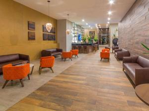 a lobby of a hotel with couches and chairs at Novotel Medellin El Tesoro in Medellín