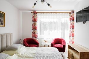 sypialnia z łóżkiem i 2 czerwonymi krzesłami w obiekcie Karina w Wiśle