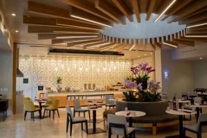 a restaurant with tables and chairs and a large chandelier at Hilton San Salvador in San Salvador