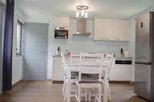 a kitchen with white cabinets and a table and chairs at LE GLAWAN in Barvaux