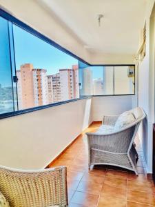 ein Balkon mit zwei Stühlen und einem großen Fenster in der Unterkunft House Relax Parque das Águas Quentes - Apê 2 Quartos in Caldas Novas