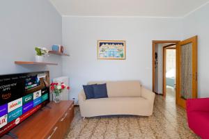 een woonkamer met een bank en een televisie bij La Serena di Bordighera Vintage Flat in Bordighera