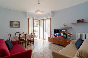een woonkamer met een bank, een tv en een tafel bij La Serena di Bordighera Vintage Flat in Bordighera
