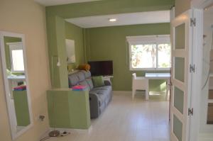 a living room with a couch and a television at Excepcional Apartamento LOFT a pie de playa en CHALET ROQUETES in Alicante