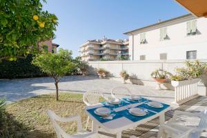 een tafel met witte stoelen en een blauwe tafel bij La Serena di Bordighera Vintage Flat in Bordighera
