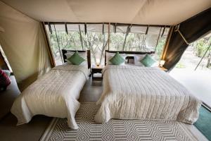 Ein Bett oder Betten in einem Zimmer der Unterkunft Olkinyei Mara Tented Camp