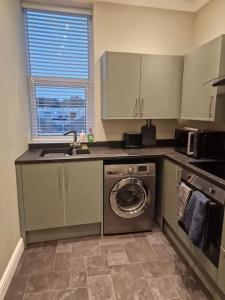 a kitchen with a sink and a washing machine at Levy Nook 4 in Darlington