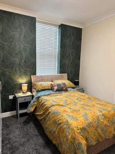 a bedroom with a bed with a yellow blanket and a window at Levy Nook 4 in Darlington