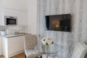 sala de estar con mesa de cristal y TV en Edinburgh Castle Apartments, en Edimburgo