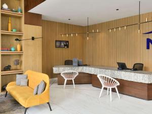 a lobby with two chairs and a reception desk at Novotel Jodhpur ITI Circle in Jodhpur