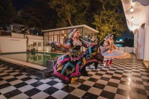 two women in costumes standing on a checkered floor at The Experience Resort-Lake Facing in Udaipur