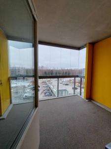 an empty room with a view of a parking lot at Kotimaailma - Avara ja valoisa studio Vantaalla in Vantaa