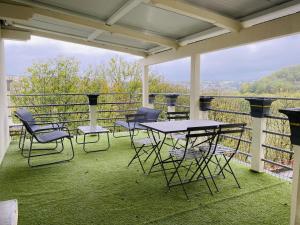 een patio met tafels en stoelen op een balkon bij Le haut layoule in Rodez