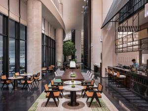 a restaurant with tables and chairs in a building at Pullman Quanzhou Shuitou in Quanzhou