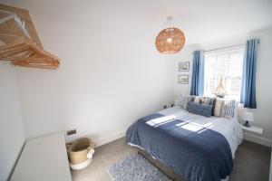 1 dormitorio con cama y ventana en La Casita - Inside the Gates of Frinton-On-Sea, en Frinton-on-Sea