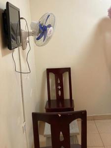 NamugongoにあるTwinkle Blue Innの木製の椅子、ファン、テレビが備わります。