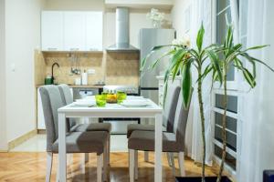 a white dining room table with chairs and a plant at Apartman Centar&Privatno garažno mesto in Požarevac
