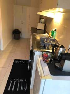 a kitchen with a sink and a counter top at La Maison des roses in Nanterre