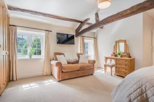 a bedroom with a bed and a chair and a mirror at farmhouse braithwaite mews in Keswick