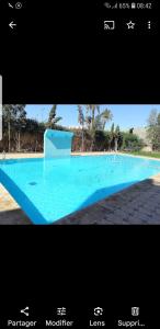 uma imagem de uma grande piscina azul em premium village 106 em Marrakech