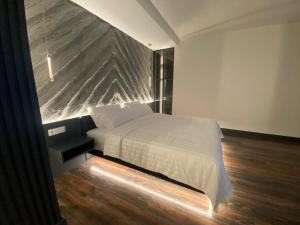 a bedroom with a bed and a large stone wall at Tirana Central Rooms in Tirana