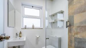 a bathroom with a sink and a toilet and a window at Glamorous 1 BDR Duplex Apartment by LovelyStay in Tavira +14 photos