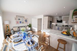 a kitchen and living room with a table and chairs at La Casita - Inside the Gates of Frinton-On-Sea in Frinton-on-Sea